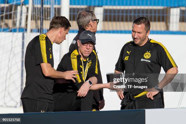 Assistant coach Joerg Heinrich of Dortmund speaks with Head coach Peter Stoeger of Dortmund and Assistant coach Manfred Schmid of Dortmund during the...