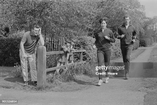 British athletes Ann Packer and Robbie Brightwell running past a front yard, UK, 23rd May 1968.