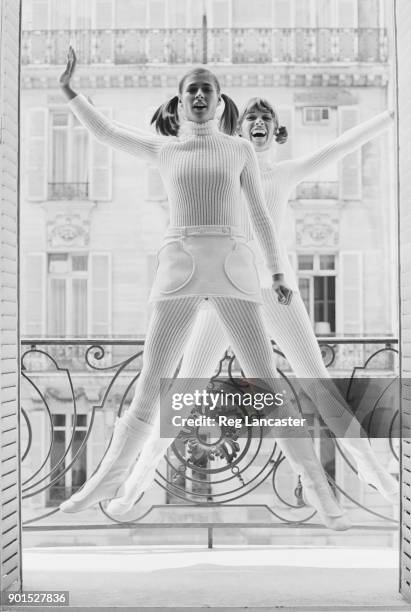 Two fashion model wearing a white jumpsuit, white mini skirt and white boots, 7th August 1968.