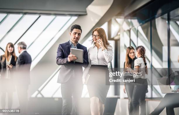 business-leute diskutieren im büro - geschäftsmann im büro mobiltelefon stock-fotos und bilder