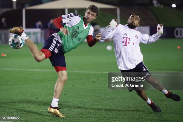 Thomas Mueller is challenged by Arturo Vidal during a training session on day 4 of the FC Bayern Muenchen training camp at ASPIRE Academy for Sports...