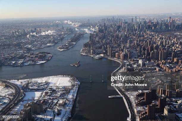 Manhattan and the Queens boroughs bisected by the East River lie under a blanket of snow on January 5, 2018 in New York City. Under frigid...