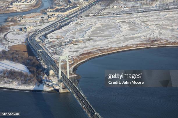 Traffic moves over the Bronx-Whitestone Bridge next to the snow-blanketed Trump Golf Links at Ferry Point on January 5, 2018 in the Bronx...