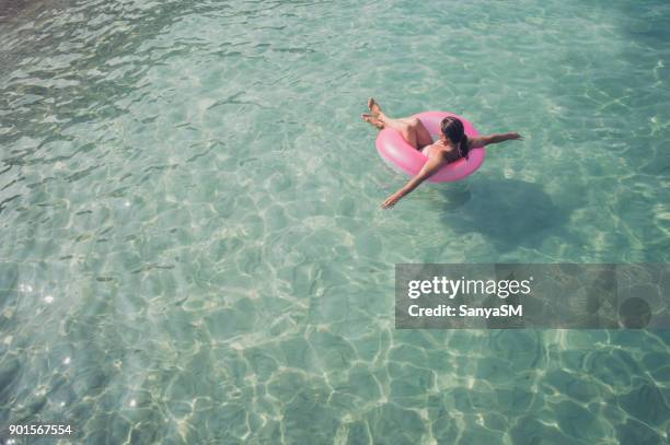 senior vrouw geniet van zeewater - zwemband stockfoto's en -beelden