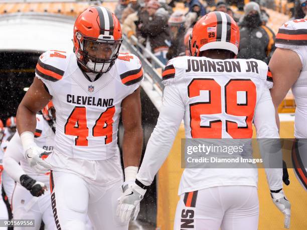 Defensive lineman Nate Orchard of the Cleveland Browns high fives running back Duke Johnson Jr. #29, as they run onto the field prior to a game on...