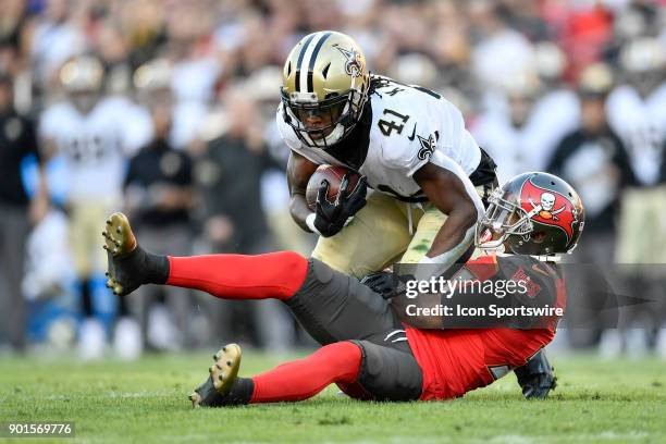 New Orleans Saints running back Alvin Kamara is pulled down by Tampa Bay Buccaneers cornerback Javien Elliott during the first half of an NFL game...