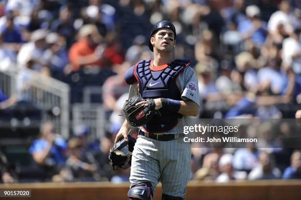 Catcher Joe Mauer of the Minnesota Twins looks to the first baseman to make the play on a foul pop fly during the game against the Kansas City Royals...