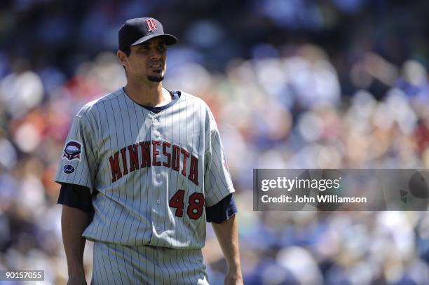 Pitcher Carl Pavano of the Minnesota Twins looks up at the crowd as he walks back to the dugout after retiring the side during the game against the...