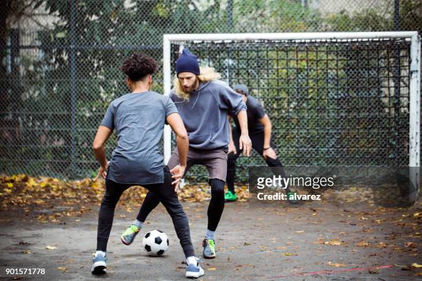 自信を持って男性が相手からボールをドリブル - street sports ストックフォトと画像