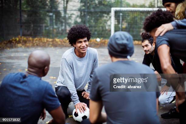 smiling soccer player planning strategy with team - team captain stock pictures, royalty-free photos & images