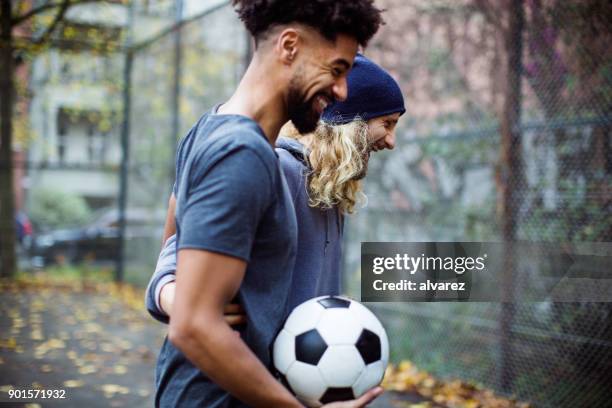 glücklich fußball-spieler mit ball am feld sprechen - soccer men stock-fotos und bilder