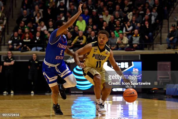Purdue Boilermakers guard P.J. Thompson dribbles by Tennessee State Tigers guard Armani Chaney during the college basketball game between the...