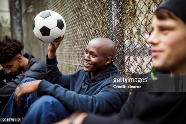 player sitting with his soccer team against fence - soccer team stock pictures, royalty-free photos & images