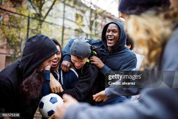 happy team enjoying while playing soccer in city - match for solidarity stock pictures, royalty-free photos & images