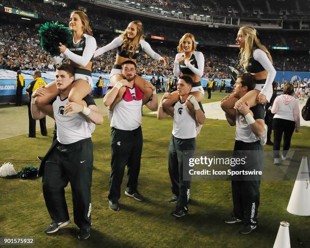 Michigan State Spartans cheerleaders have fun on the field in the second half of the Holiday Bowl played against the Washington State Cougars, on...