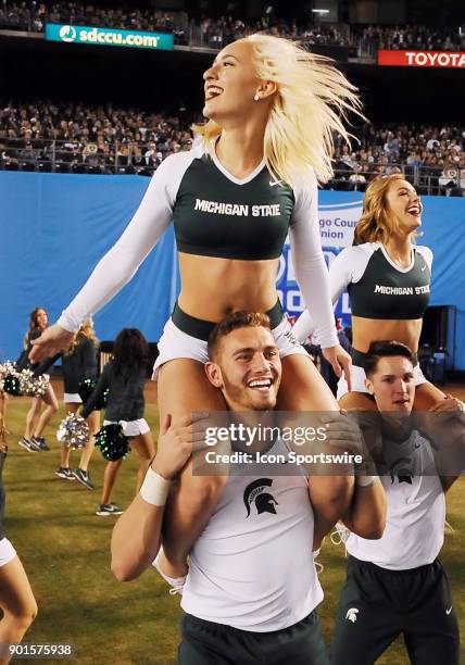 Michigan State Spartans cheerleaders have fun on the field in the second half of the Holiday Bowl played against the Washington State Cougars, on...