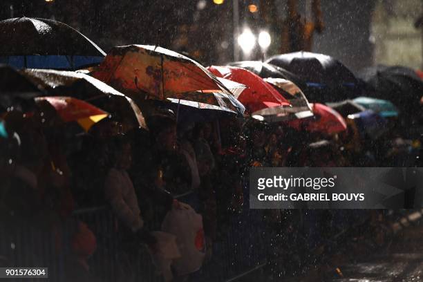 Children stand under the rain as they attend the traditional Three Kings parade marking Epiphany in Madrid on January 5, 2018. / AFP PHOTO / GABRIEL...