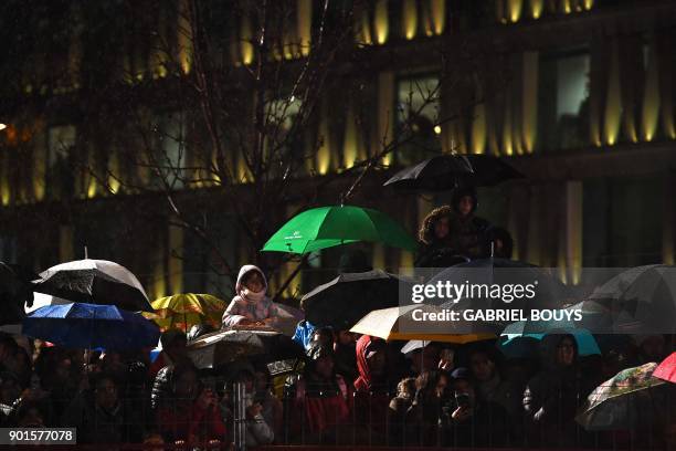 Children stand under the rain as they attend the traditional Three Kings parade marking Epiphany in Madrid on January 5, 2018. / AFP PHOTO / GABRIEL...