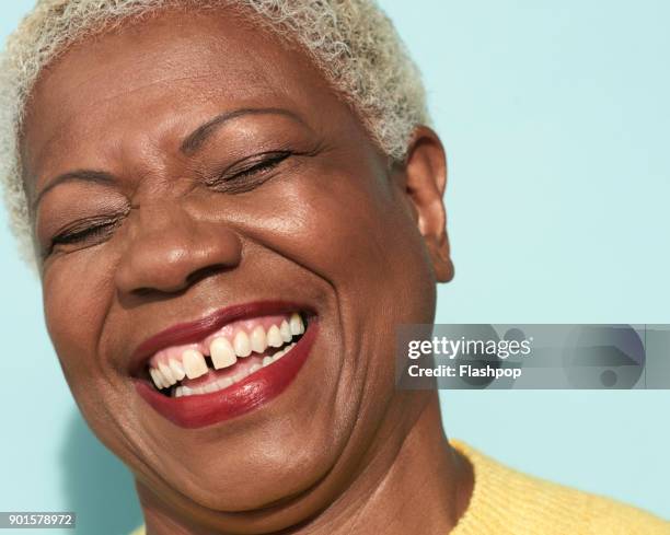 portrait of mature woman laughing - vrouw spleetje tanden stockfoto's en -beelden