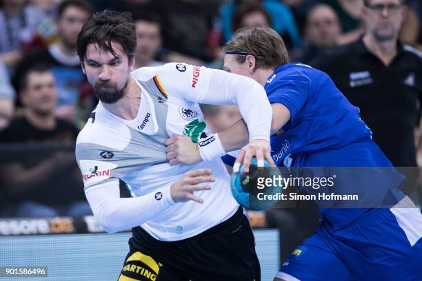 Fabian Wiede of Germany is challenged Janus Smarson of Iceland during the International Handball Friendly match between Germany and Iceland at...