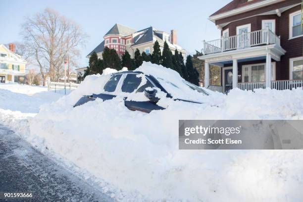 Snowed in vehicle is left parked the day after the region was hit with a "bomb cyclone" on January 5, 2018 in the Dorchester neighborhood of Boston,...