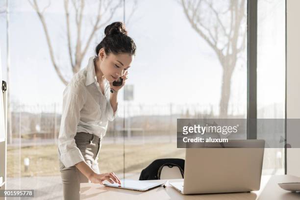 asiatische geschäftsfrau auf dem telefon und digital-tablette mit - happy asian woman bright office stock-fotos und bilder