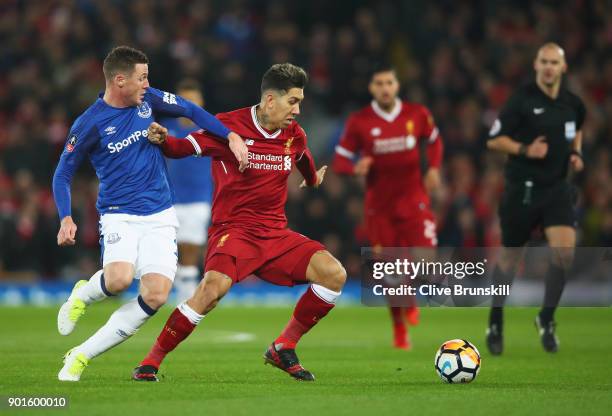 Roberto Firmino of Liverpool holds off James McCarthy of Everton during the Emirates FA Cup Third Round match between Liverpool and Everton at...