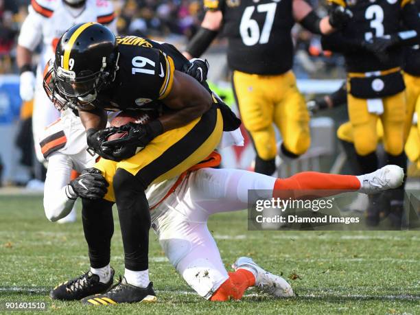 Wide receiver JuJu Smith-Schuster of the Pittsburgh Steelers is tackled by cornerback Briean Boddy-Calhoun of the Cleveland Browns in the first...