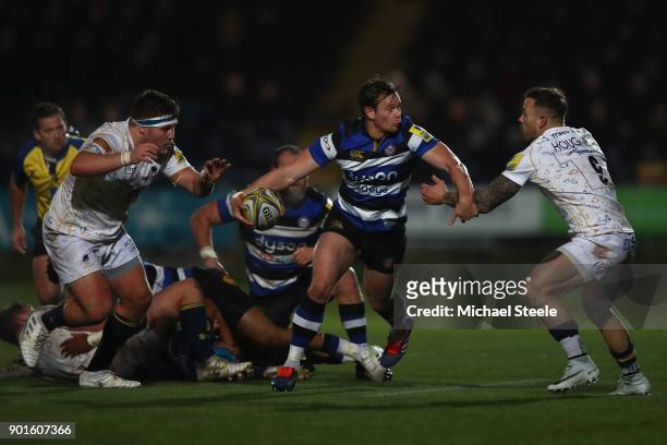 Chris Cook of Bath looks to offload as Francois Hougaard and GJ van Velze of Worcester close in during the Aviva Premiership match between Worcester...