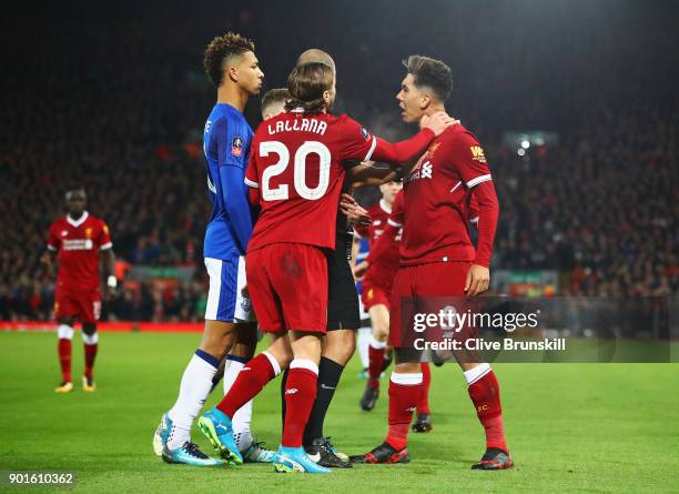 Referee Robert Madley and Adam Lallana of Liverpool intervene as Mason Holgate of Everton and Roberto Firmino of Liverpool clash during the Emirates...