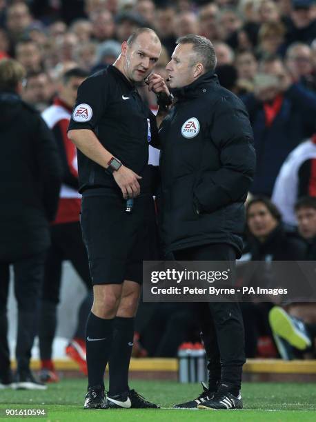 Referee Bobby Madley speaks to the fourth official during the FA Cup, third round match at Anfield, Liverpool.