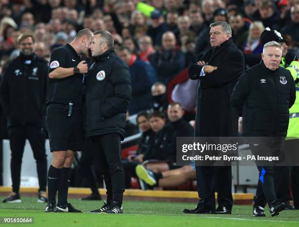 Referee Bobby Madley speaks to the fourth official during the FA Cup, third round match at Anfield, Liverpool.