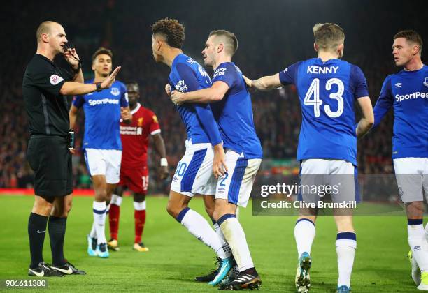 Mason Holgate of Everton is restrained by Morgan Schneiderlin of Everton after a clash with Roberto Firmino of Liverpool as referee Robert Madley...