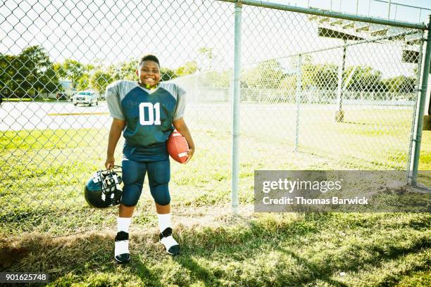 portrait of smiling young football player before football game - american football strip stock pictures, royalty-free photos & images