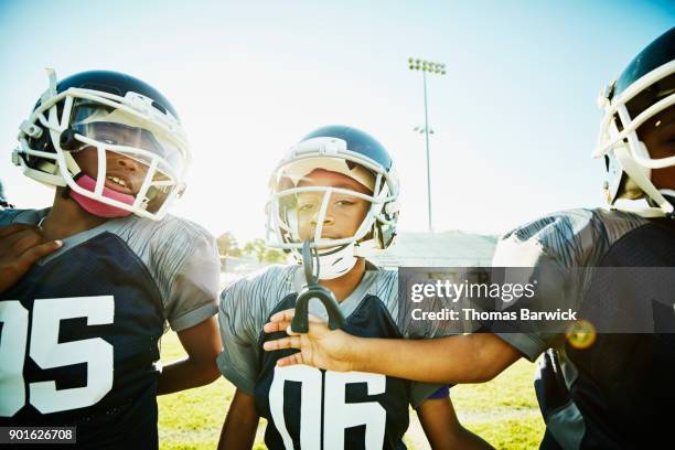 smiling young football teammates on warming up on field together before football game - studying hard stock pictures, royalty-free photos & images