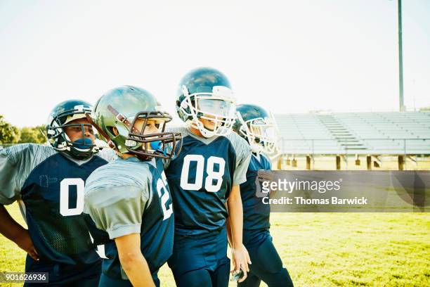 smiling football teammates standing together on field during practice - american football uniform stock pictures, royalty-free photos & images