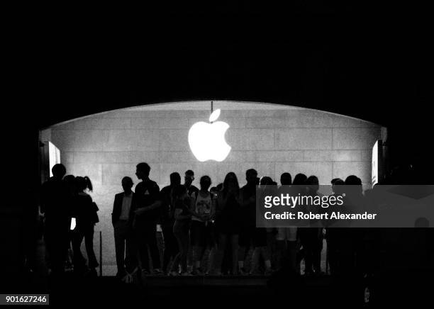 Travelers and tourists are silouetted in front of the Apple Store logo in the Main Concourse at Grand Central Terminal in New York City.