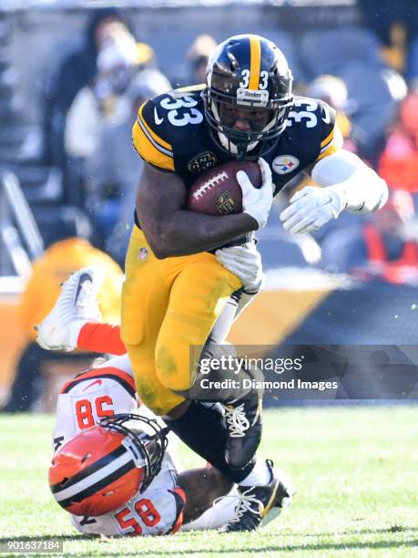 Running back Fitzgerald Toussaint of the Pittsburgh Steelers is tackled by linebacker Christian Kirksey of the Cleveland Browns in the second quarter...