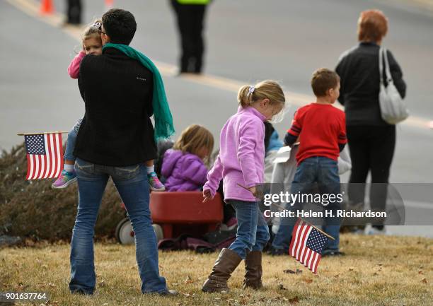 Julie Kelly, with her daughters Allie in her arms, and Riley right, pay their respects outside of Cherry Hills Community Church during the funeral...