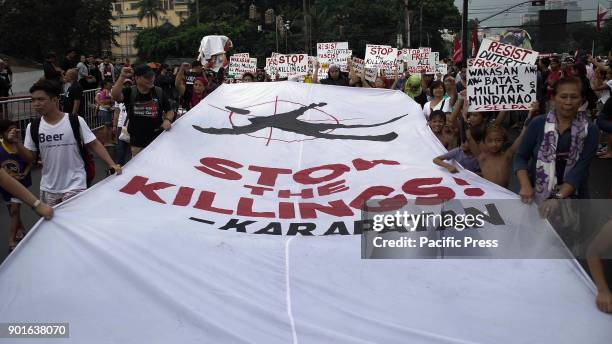 Activists carry a banner calling for the halt of extrajudicial killings during a protest in Manila, Philippines on International Day for Human...