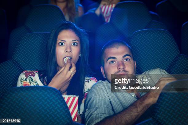 asustada pareja en un cine - horror movie fotografías e imágenes de stock