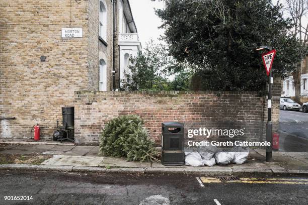 Discarded Christmas tree lies in a street in Angel on January 5, 2018 in London, England. In the lead up to Christmas a pine tree is the centre point...