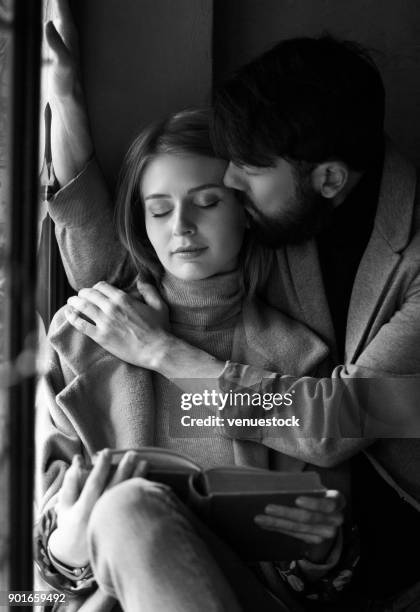 young couple reading a book together. - black and white couple stock pictures, royalty-free photos & images