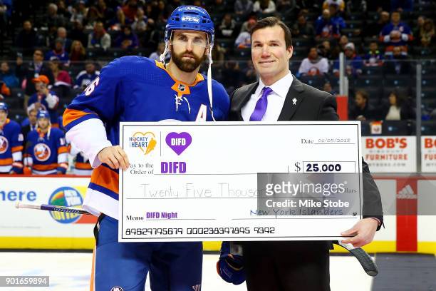 Andrew Ladd of the New York Islanders presents Luke Richardson with a ceremonial $25,000 check for Do It For Daron, an organization dedicated to...