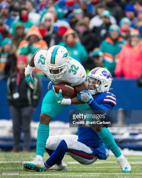 Kenyan Drake of the Miami Dolphins is tackled by Jordan Poyer of the Buffalo Bills during the first quarter at New Era Field on December 17, 2017 in...