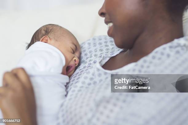 new mom holds her infant to her chest - baby delivery stock pictures, royalty-free photos & images