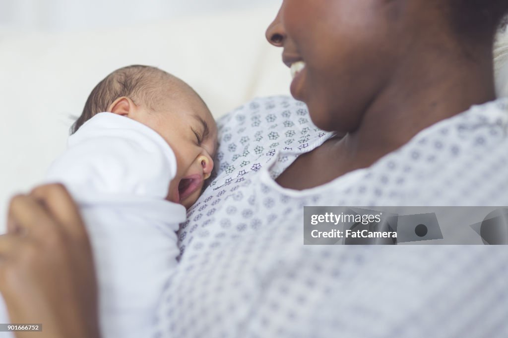 Nova mãe segura seu bebê no peito