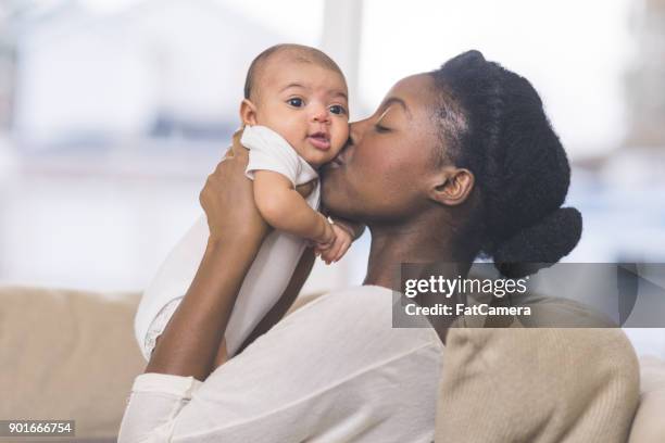 beautiful ethnic mom holds her infant girl - baby mom stock pictures, royalty-free photos & images