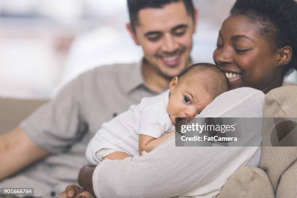 nueva mamá tiene a su bebé a su pecho - mestizo fotografías e imágenes de stock