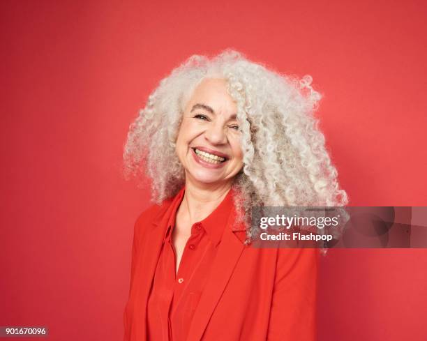 portrait of mature woman laughing - coloured background lachen stock-fotos und bilder